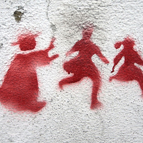 Stenciled graffiti of a priest pursuing two children