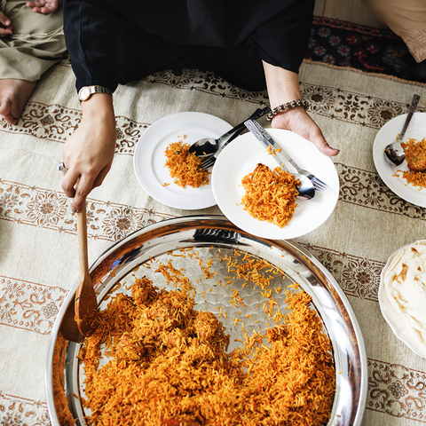 Top view of person serving themself a rice dish from a table of food