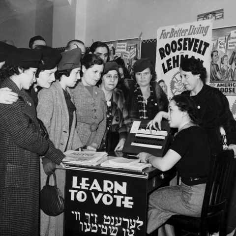 Women at desk marked "Learn to Vote"