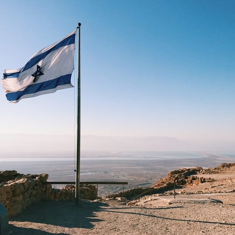 Flag of Israel with landscape of Israel in the background