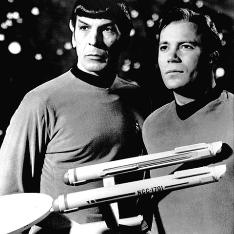 William Shatner as Captain Kirk and Leonard Nimoy as Mr. Spock pose behind a model of the starship Enterprise.