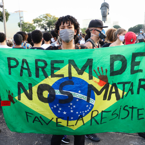 A Brazilian man holding a protest sign