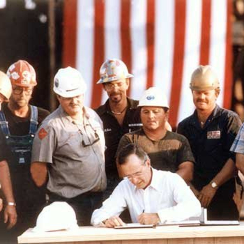 President George Bush signing deregulation papers with gas company employees looking on