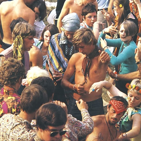 1960s hippies dancing at a festival.