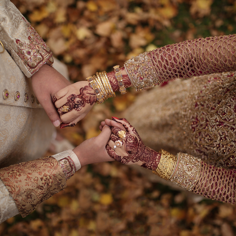 Close-up of Indian couple's hands during wedding ceremony
