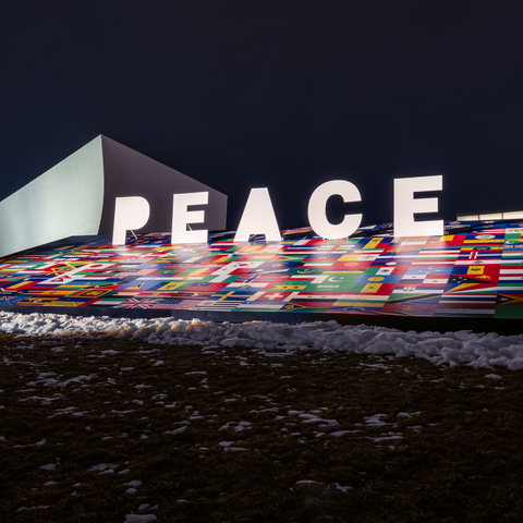 a billboard with flags of many countries and the word Peace on it.
