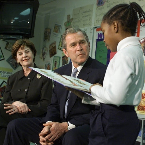 President George W. Bush and his wife Laura listening to a Missouri elementary student read aloud to them.