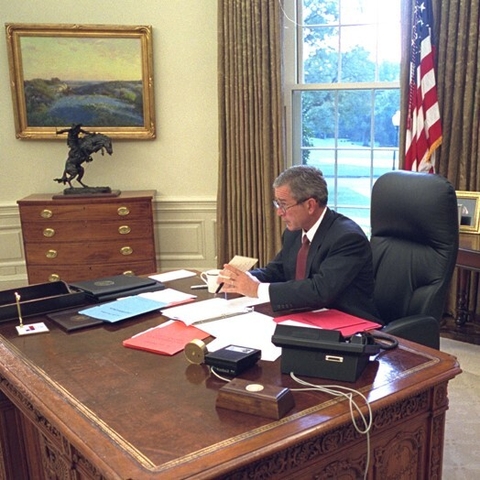 President George W. Bush sitting at his desk in 2001.
