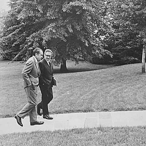 Henry Kissinger and Richard Nixon walking on White House grounds.