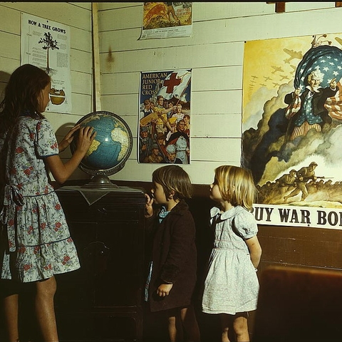 Rural school children looking at a globe in 1943.