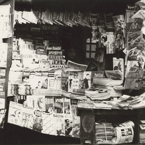 Woman reading inside a newsstand in the 1950s.