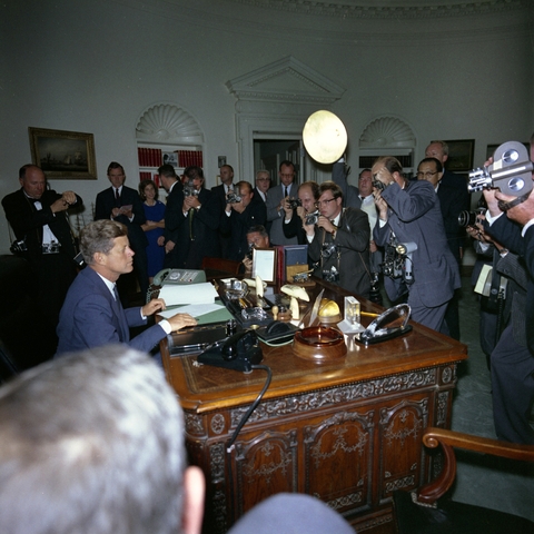 President Kennedy surrounded by cameramen after signing the Cuba Quarantine Order on October 23, 1962.