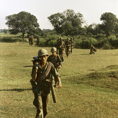 U.S. soldiers walking across a field during the Vietnam War.