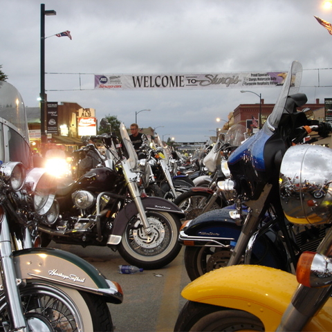 A view down Main Street between motorcycles with a banner welcoming riders to the 2005 Sturgis Motorcycle Rally.