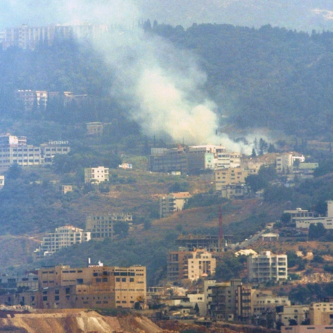 A plume of smoke rising from a neighborhood in Beirut following an Israeli strike in 2006.