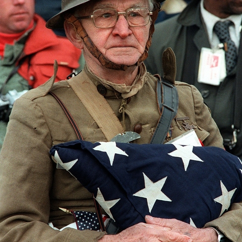 Joseph Ambrose, an 86-year-old World War I veteran, attends the dedication day parade for the Vietnam Veterans Memorial in 1982. Wearing a doughboy uniform like the ones used during the war, he is holding an American flag. It covered the casket of his son Clement, who was killed in the Korean War.
