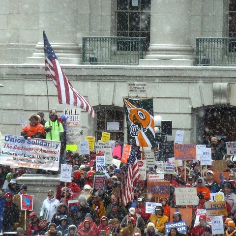 Demonstrators in steadily falling snow outside of the Wisconsin Capitol building.
