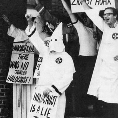 KKK members displaying the Nazi salute and Holocaust denial signs.