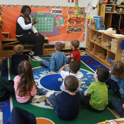 A teacher and her students in an elementary school classroom.