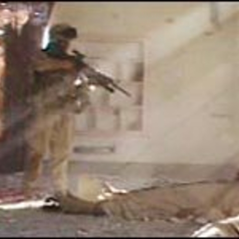 An unidentified U.S. Marine Corps corporal fires his weapon at a wounded, unarmed Iraqi lying on the floor of a gutted mosque in Fallujah, Nov. 13, 2004. by Kevin Sites found on NPR.org