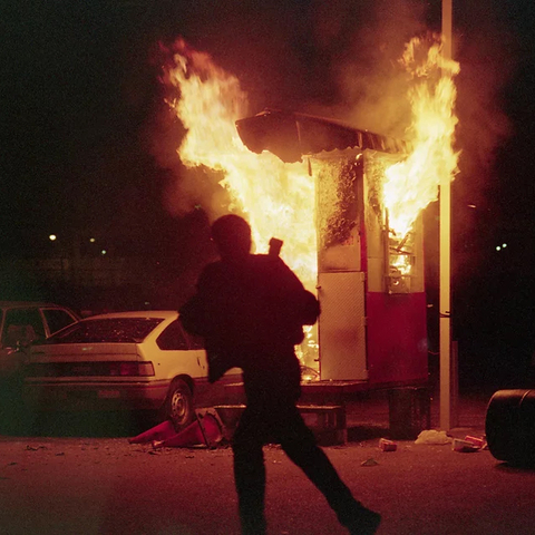 man running near a burning building - Photo by Bettmann Collection/Getty Images