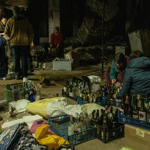 A group of Kyiv civilians gather in a basement downtown to make Molotov Cocktails to be used against Russian troops in Kyiv, Ukraine, 2022.