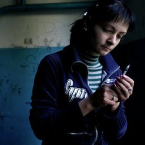 a woman holding a needle with drugs in it