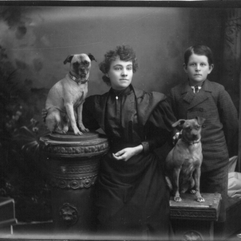 Portrait photograph of woman, boy and two dogs, ca. 1890s. 