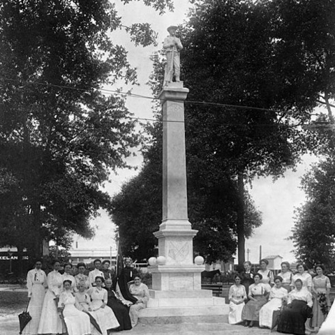 Members of the United Daughters of the Confederacy around the monument they sponsored.