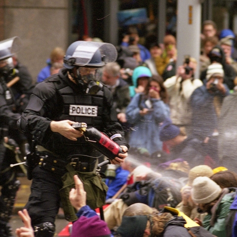 Seattle Police spraying opponents of the World Trade Organization with pepper spray.