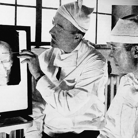 Doctors Walter Freeman (left) and James W. Watts (right) studying an X-ray.