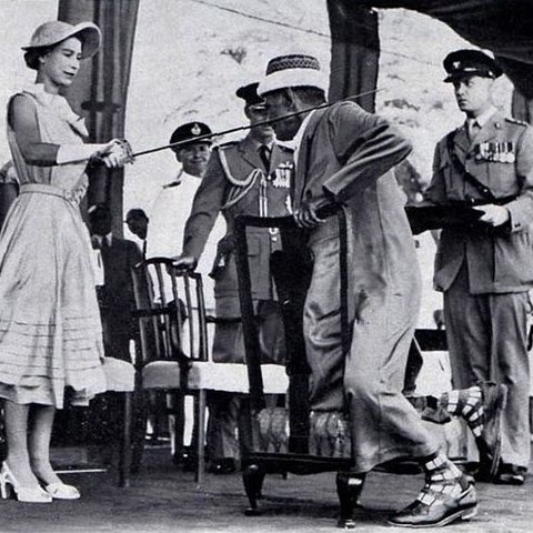 Queen Elizabeth in Aden, Yemen knighting Sayyid Abubakr in 1954.