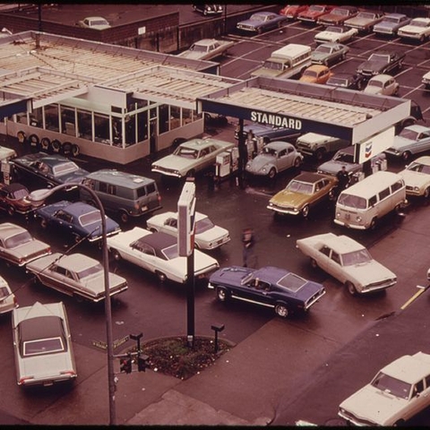 A gas station in Portland, OR during the oil shortage in 1973 with long lines of cars waiting for gas.