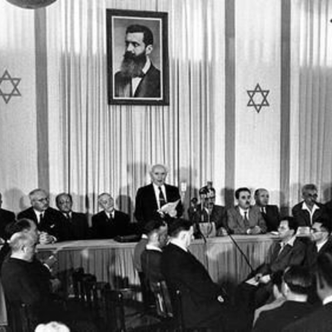 David Ben-Gurion (First Prime Minister of Israel) announcing the Declaration of the State of Israel, May 14 1948, Tel Aviv, Israel, beneath a portrait of Theodor Herzl, founder of modern Zionism