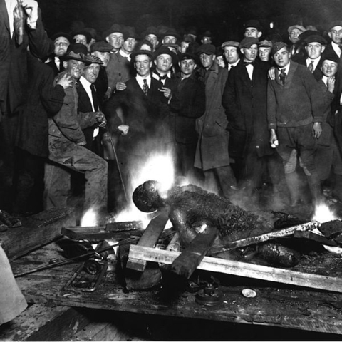 White men posing around the mutilated and charred corpse of William Brown in Omaha, NE in 1919.