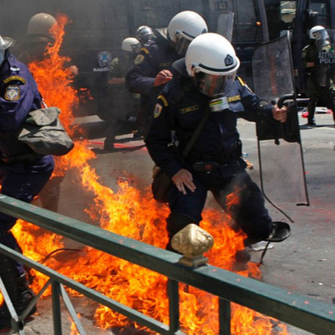 Greek police officers set ablaze by petrol bombs thrown by protesters during 2010 May Day demonstrations.