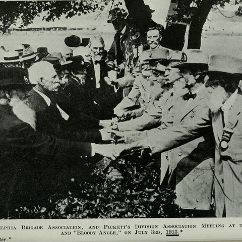 Confederate and Union veterans shaking hands.