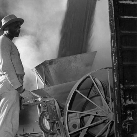 A worker watching the loading of powder fine phosphate in Mulberry, FL in 1947.