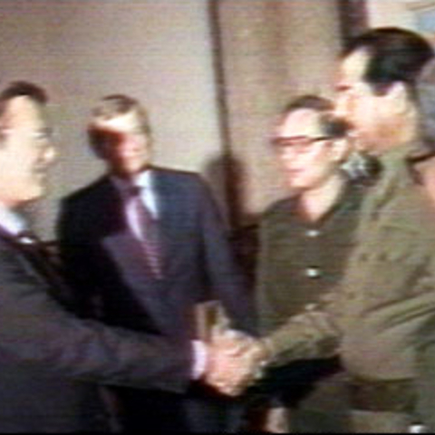 Donald Rumsfeld, special envoy of President Ronald Reagan, greets Saddam Hussein in Baghdad on December 20, 1983