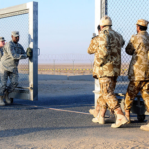 U.S. and Kuwaiti troops close the gate between Kuwait and Iraq after the last military convoys pass through on December 18, 2011.