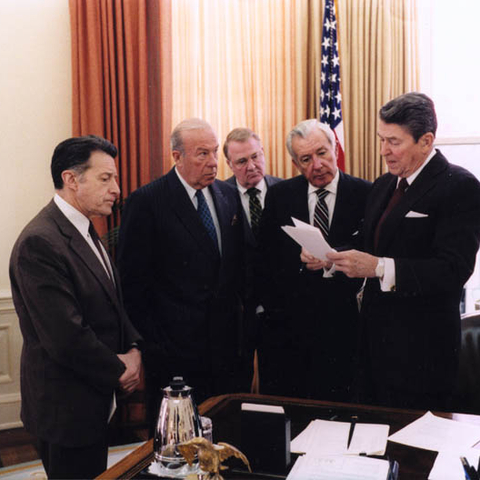 U.S. President Ronald Reagan in the Oval Office with Caspar Weinberger, George Shultz, Ed Meese, and Don Regan discussing Reagan's remarks on the Iran-Contra affair