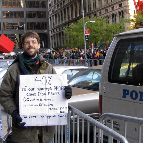 A protestor at the Occupy Wall Street Protests in 2011 with a sign calling for the re-regulation of banks.