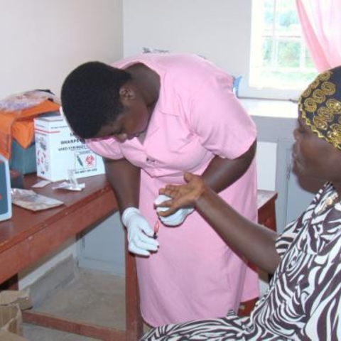 A midwife in Uganda drawing a patient’s blood.