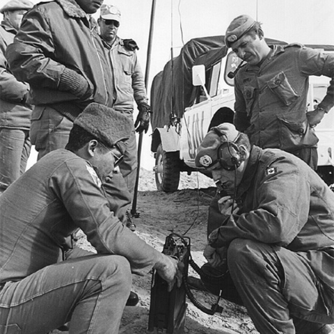 Canadian and Panamanian peacekeepers inspect a radio while stationed in the Sinai in 1974.