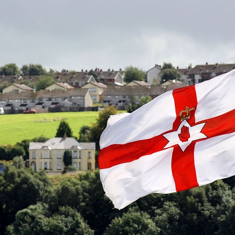 Ulster banner flying over Unionist area and the Irish flag flying over a nationalist area.