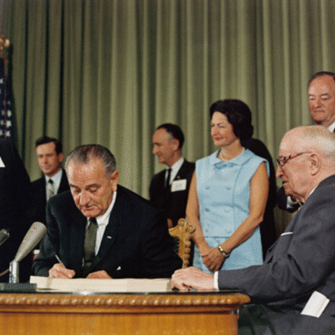 President Lyndon B. Johnson signs the Medicare Bill.