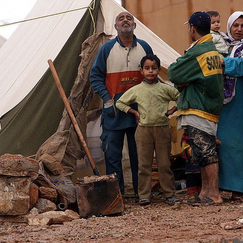 A family poses for the camera near the Iraqi/Jordanian border as Coalition Forces and members of the United Nations survey their camp in 2006.