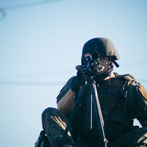 A St. Louis police officer stands atop a SWAT vehicle.