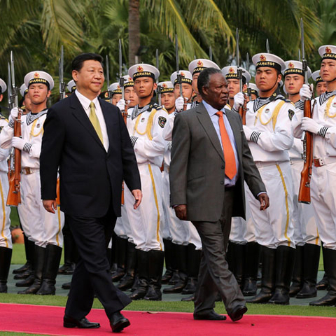 China's President Xi Jinping walks with Zambian President Michael Chilufya Sata.