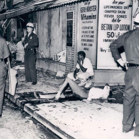 A man in bleeds on the sidewalk after he is shot by police in Watts.